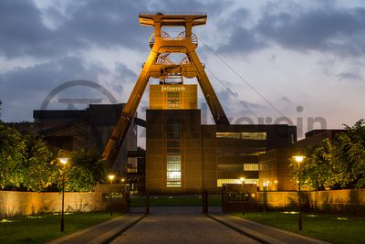 Die Geschichte Zollvereins beginnt in den Pioniertagen des heutigen Ruhrgebiets. Der erste Schacht wurde 1847 abgeteuft, vier Jahre später die erste Kohle gefördert: Vier weitere Anlagen entstanden, die letzte war die Schachtanlage Zollverein XII,  die ab 1932 die Förderung der gesamten Zollverein-Kohle zentral übernahm. 

Die Gebäude der 1928 bis 1932 im Stil der „Neuen Sachlichkeit“ nach Entwürfen der Architekten Fritz Schupp und Martin Kremmer gebauten Anlage sind nach dem Prinzip „Form follows function“ zum optimalen Ablauf der Kohleförderung und -aufbereitung angeordnet. Trotz Rekordzahlen wie 12.000 Tagestonnen verwertbarer Steinkohle machte das Ende der Schwerindustrie auch vor Zollverein nicht Halt. Am 23. Dezember 1986 fuhr die letzte Schicht ein. An diesem Tag stand die Zeche bereits unter Denkmalschutz, 1990 begannen die Sanierungsarbeiten und seit 2001 sind Zeche und Kokerei Zollverein UNESCO-Welterbe. Mit dem Denkmalpfad Zollverein, dem Ruhr Museum und dem Red Dot Design Museum sind auf Schacht XII drei der beliebtesten Touristenziele der Region angesiedelt. Das Doppelbock-Fördergerüst der Schachtanlage ist heute ein Wahrzeichen für das gesamte Ruhrgebiet. 

Das 55 Meter hohe Doppelbock-Fördergerüst ist das Wahrzeichen der Zeche Zollverein, der Stadt Essen und der gesamten Region: Die als Doppelstrebengerüst in Vollwandbauweise konstruierte Förderanlage ermöglichte eine doppelte Fördermechanik, mittels derer die doppelte Menge Förderwagen bzw. Fördergefäße transportiert werden konnten. Zollverein Schacht XII galt zu Betriebszeiten als die leistungsstärkste Zeche der Welt. 250 Stufen führen auf die oberste Plattform des Gerüstes, deren Seilscheiben sich auch heute noch drehen: Der Schacht wird heute von der RAG AG für die zentrale Wasserhaltung genutzt.