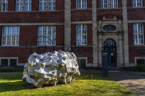 Die Sonne bringt den 590 Kilo schweren „Asteroid PF751ZH“ vor dem Verwaltungsgebäude der Stiftung Zollverein zum Glänzen. Seit 2019 liegt dort die zwei Meter hohe und drei Meter breite Skulptur des Stahlbildhauers HEX. Die Skulptur gehört zu einer Reihe von Asteroid-Skulpturen des Künstlers und entstand 2017.